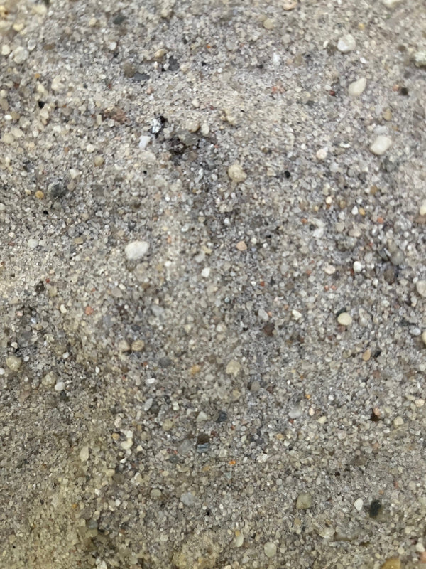 Fallschutzsand 0,2-2,0 mm – Nahaufnahme der feinkörnigen, wäschefeuchten Sandstruktur