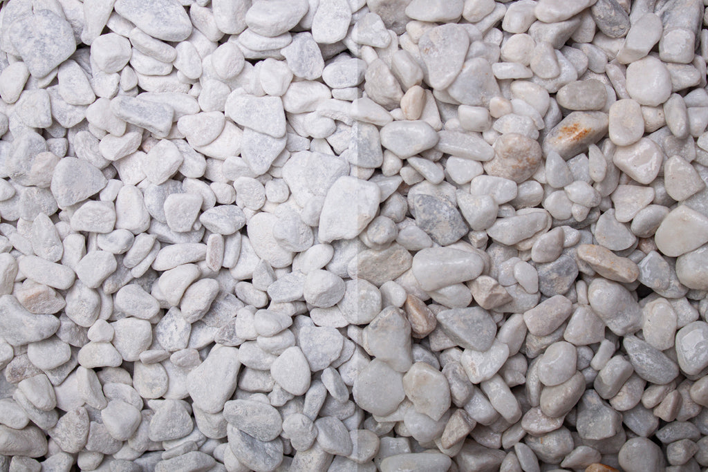 Carrara Marmor getrommelt 7-15 mm – Nahaufnahme trocken (links) und nass (rechts) im Vergleich