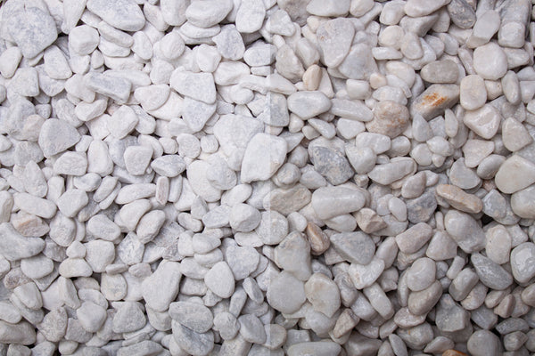Carrara Marmor getrommelt 7-15 mm – Nahaufnahme trocken (links) und nass (rechts) im Vergleich