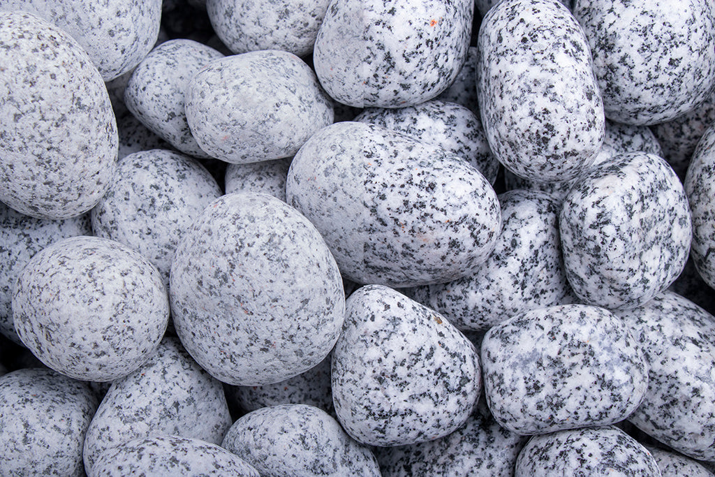 Gletscherkies Granit 25-50 mm – Nahaufnahme trocken (links) und nass (rechts) im Vergleich