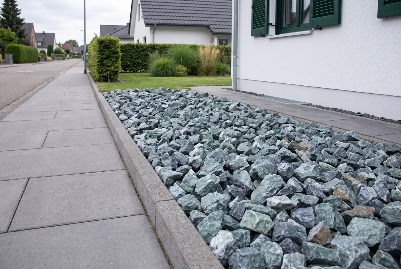 Marmor Grün SS, 40-80 mm – Anwendungsbeispiel: im Zierkiesbeet am Haus